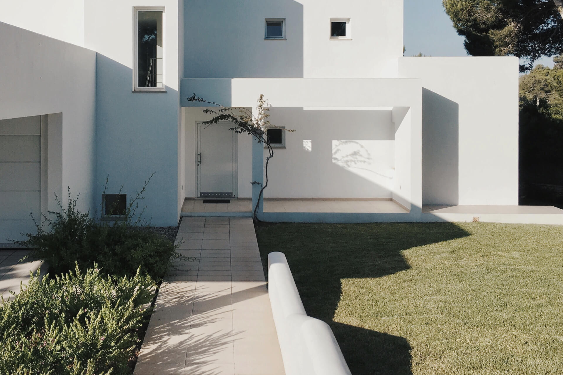 Modern white building over calm water under a blue sky